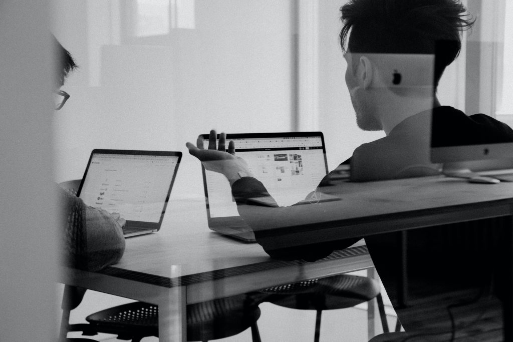 colleagues in conversation at laptops